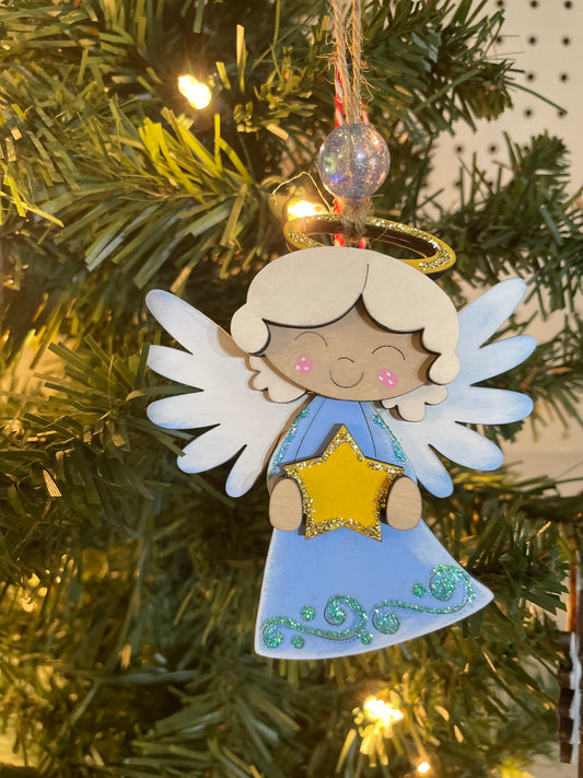 Decorative angel ornament on a Christmas tree with twinkling lights.